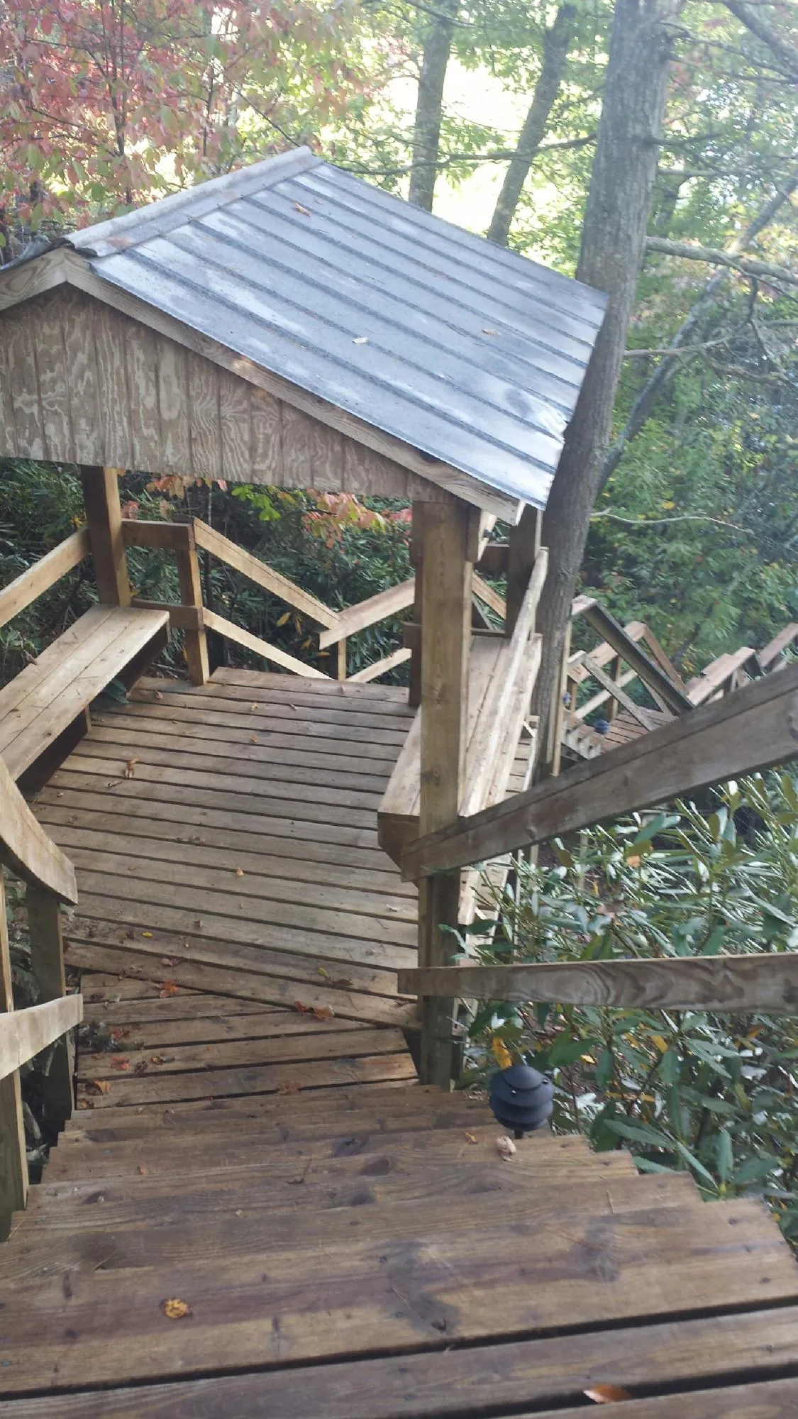 Metal roofed shelter over wooden steps on a wooded walkway — Skylight Repair & Installation work by our crew in Stanhope