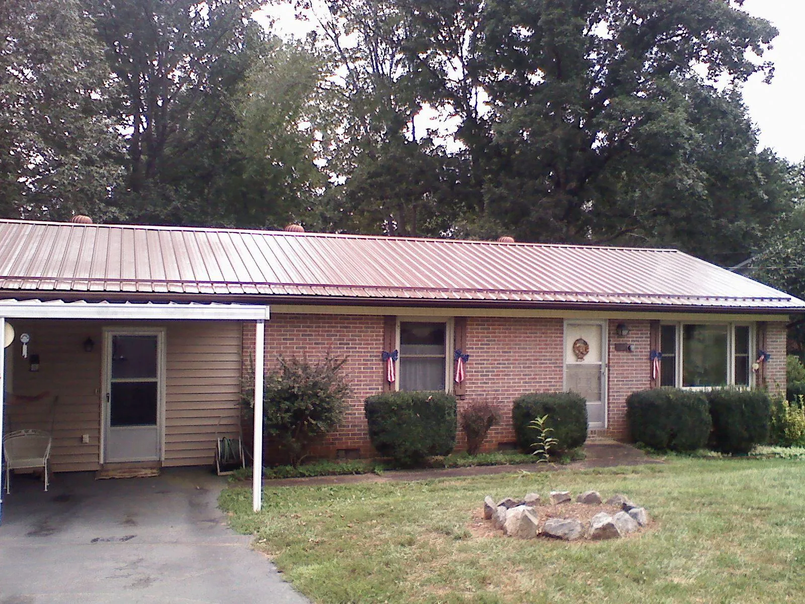 Bronze metal roof and carport on a brick ranch home — Roof Repair work by our crew in Stanhope